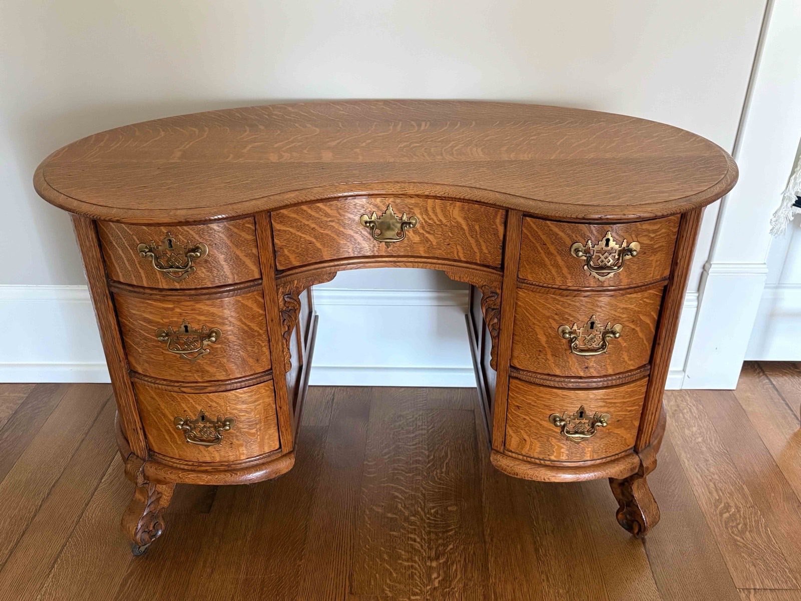 Quarter-sawn oak kidney desk with brass pulls, photographed in the home before a Nashville estate auction